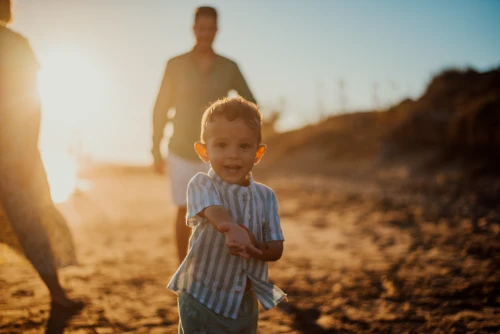 Niño disfrutando con su familia la Sesión en la playa